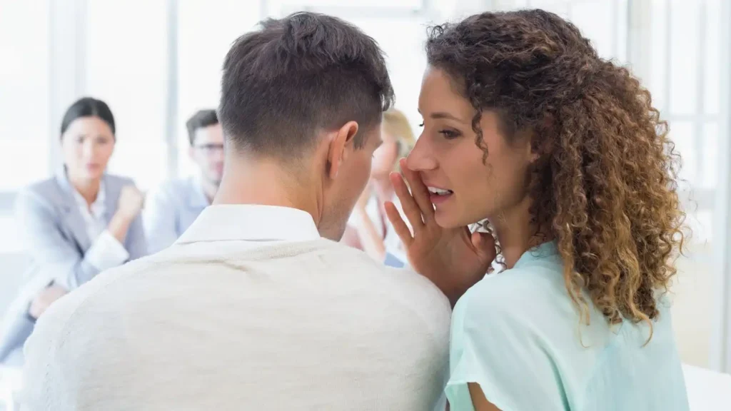 Woman whispering to man