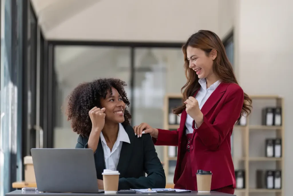 Two women colleagues smiling. 