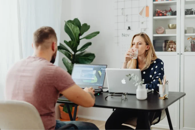 Job interview in progress with a hiring manager speaking to a candidate seated across a desk in a modern office.