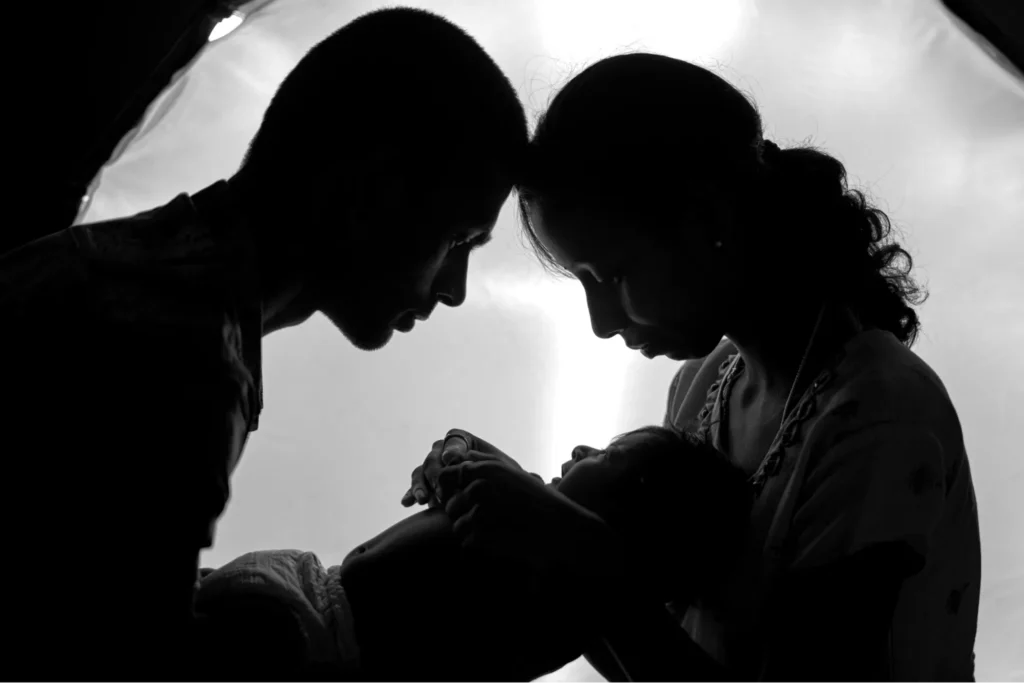 Silhouette of parents holding their baby
