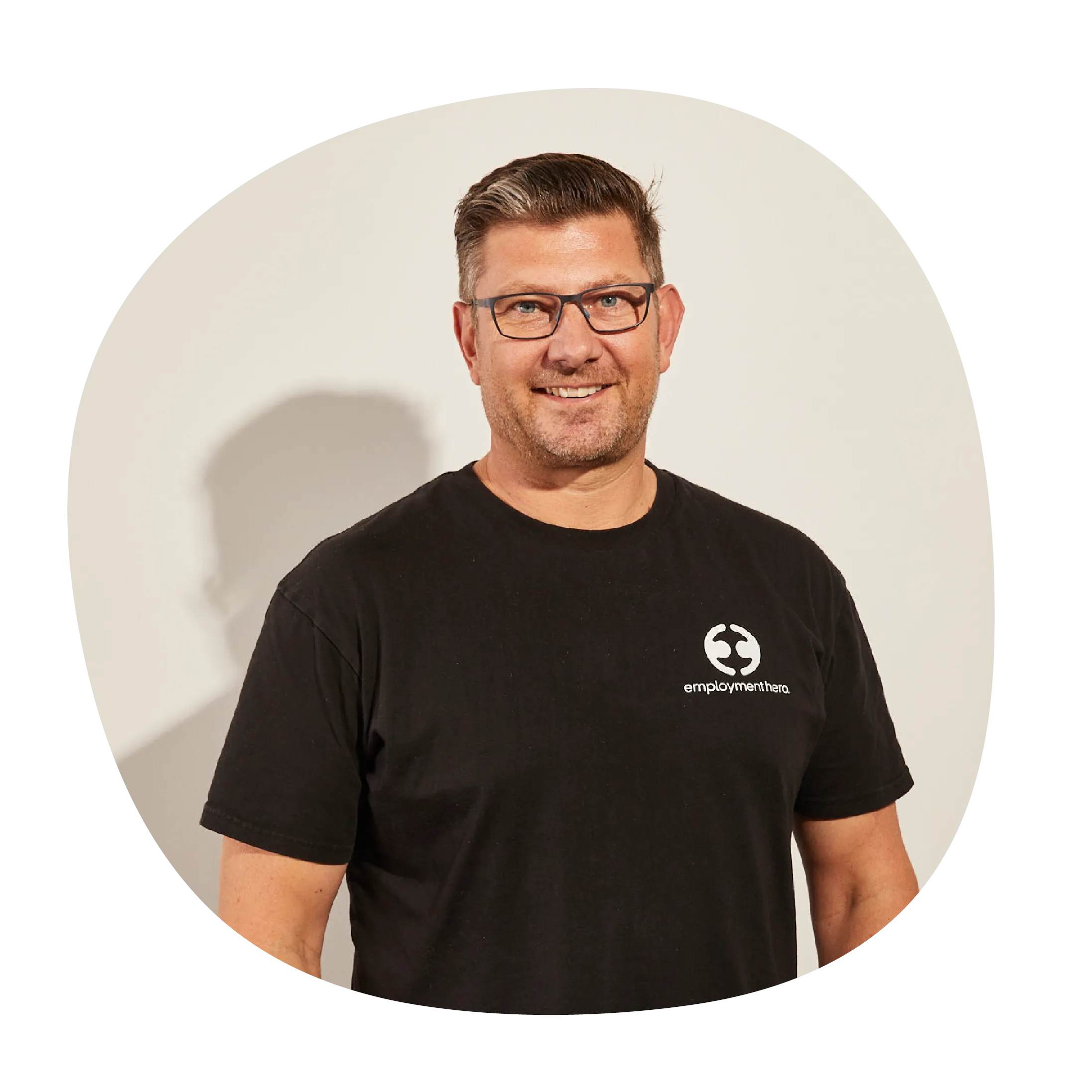 Ben Thompson wearing a black t-shirt with Employment Hero's white logo on the side. 