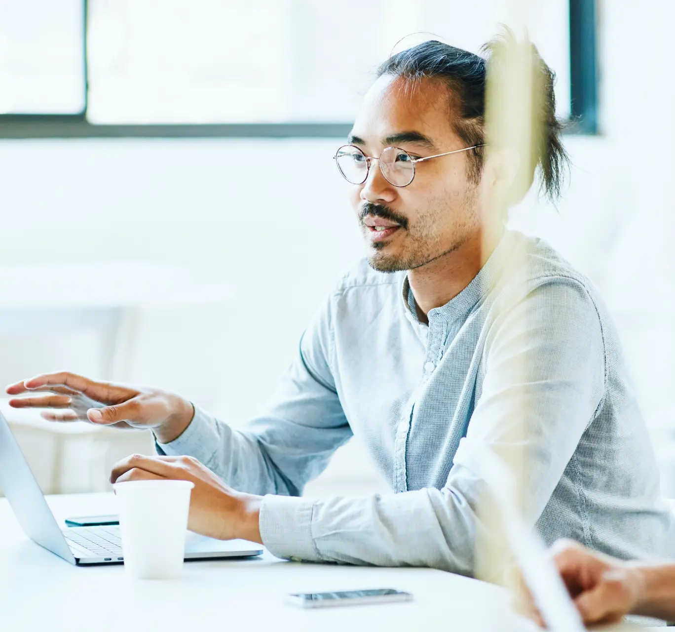 Professional working on a laptop in a meeting.