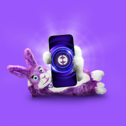 Purple plush bunny holding smartphone with glowing digital graphic on screen