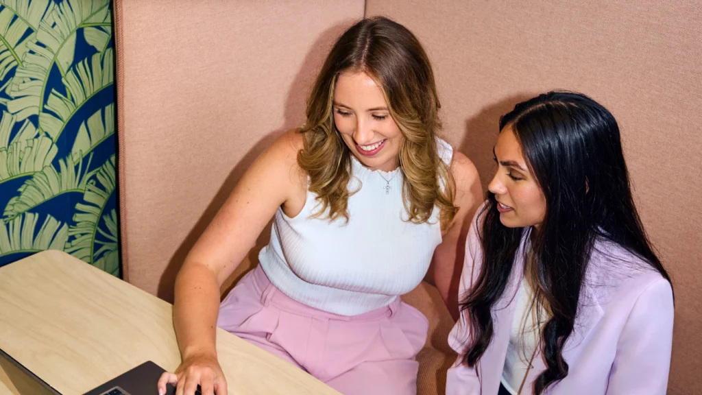 Two women talking and collaborating with a laptop