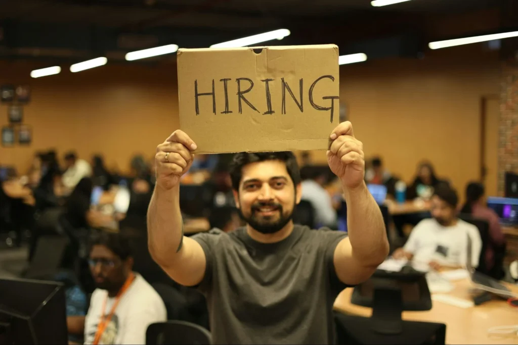 Man holding up a Hiring sign