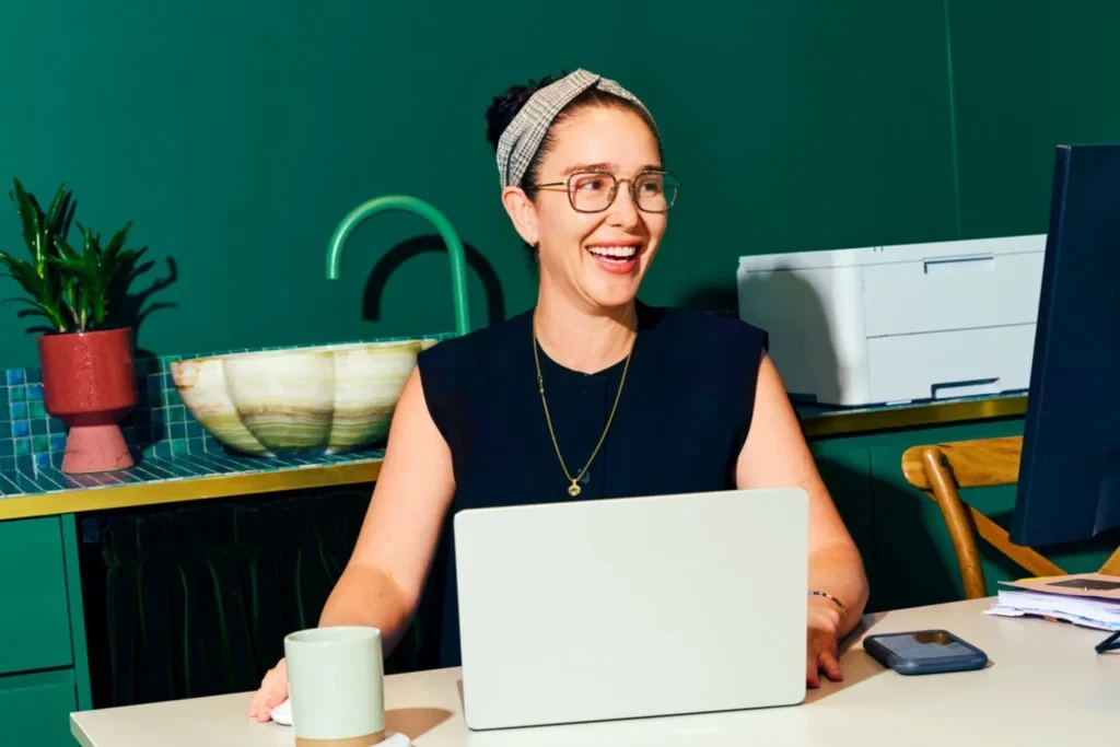 Woman smiling as she's working on her laptop