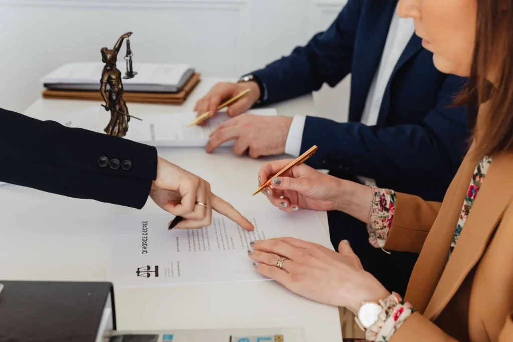 Lawyer pointing to a paper to be signed by a woman