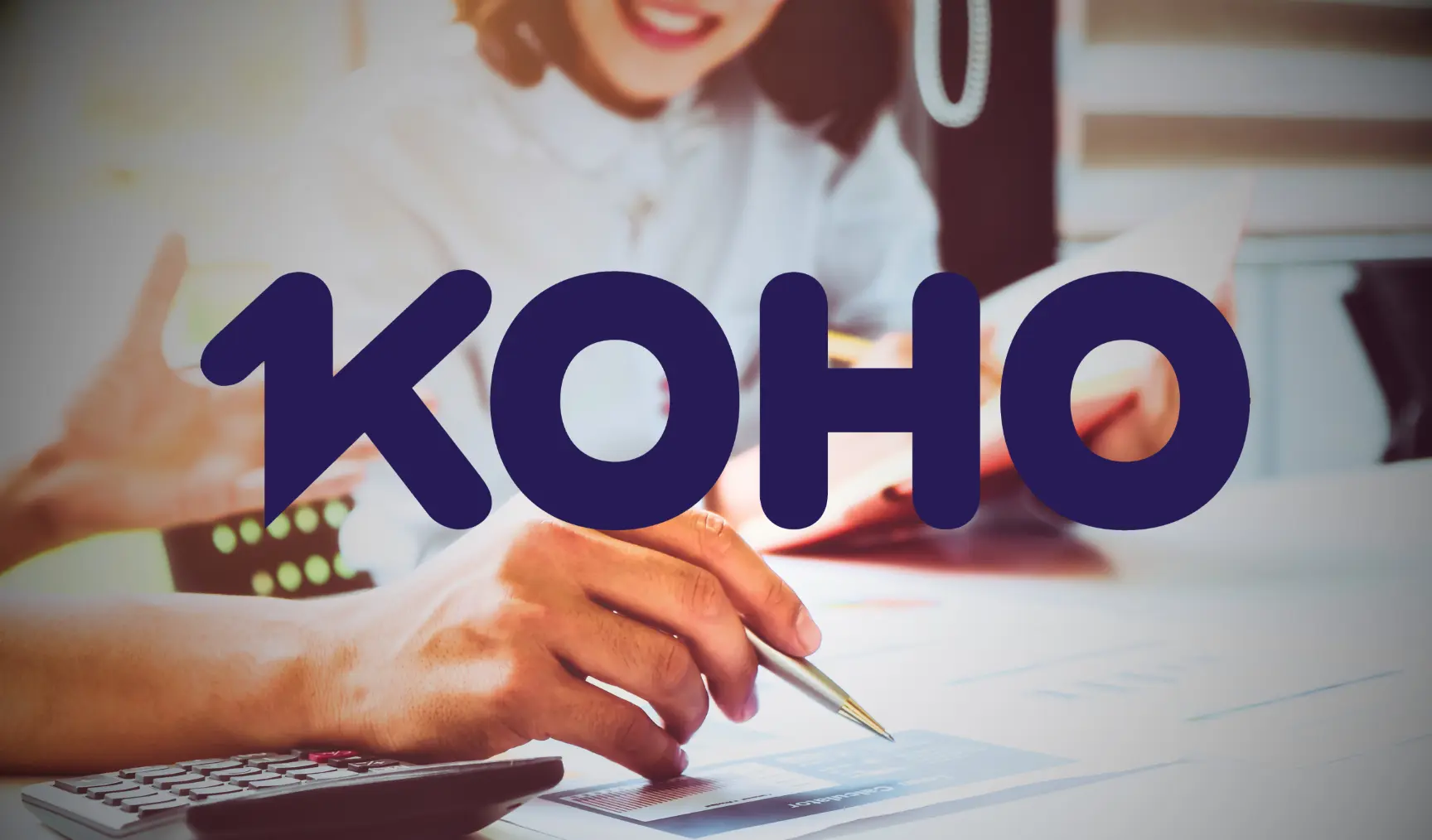 Business meeting scene with a close-up of hands pointing at documents and using a calculator. The word "KOHO" overlays the image in bold blue letters.