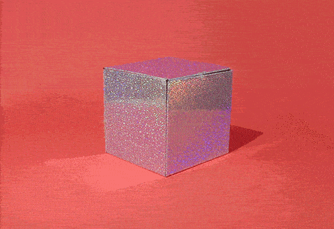 A glittery silver box on a red background unfolds, revealing a cat inside the box as it peeks out and looks around