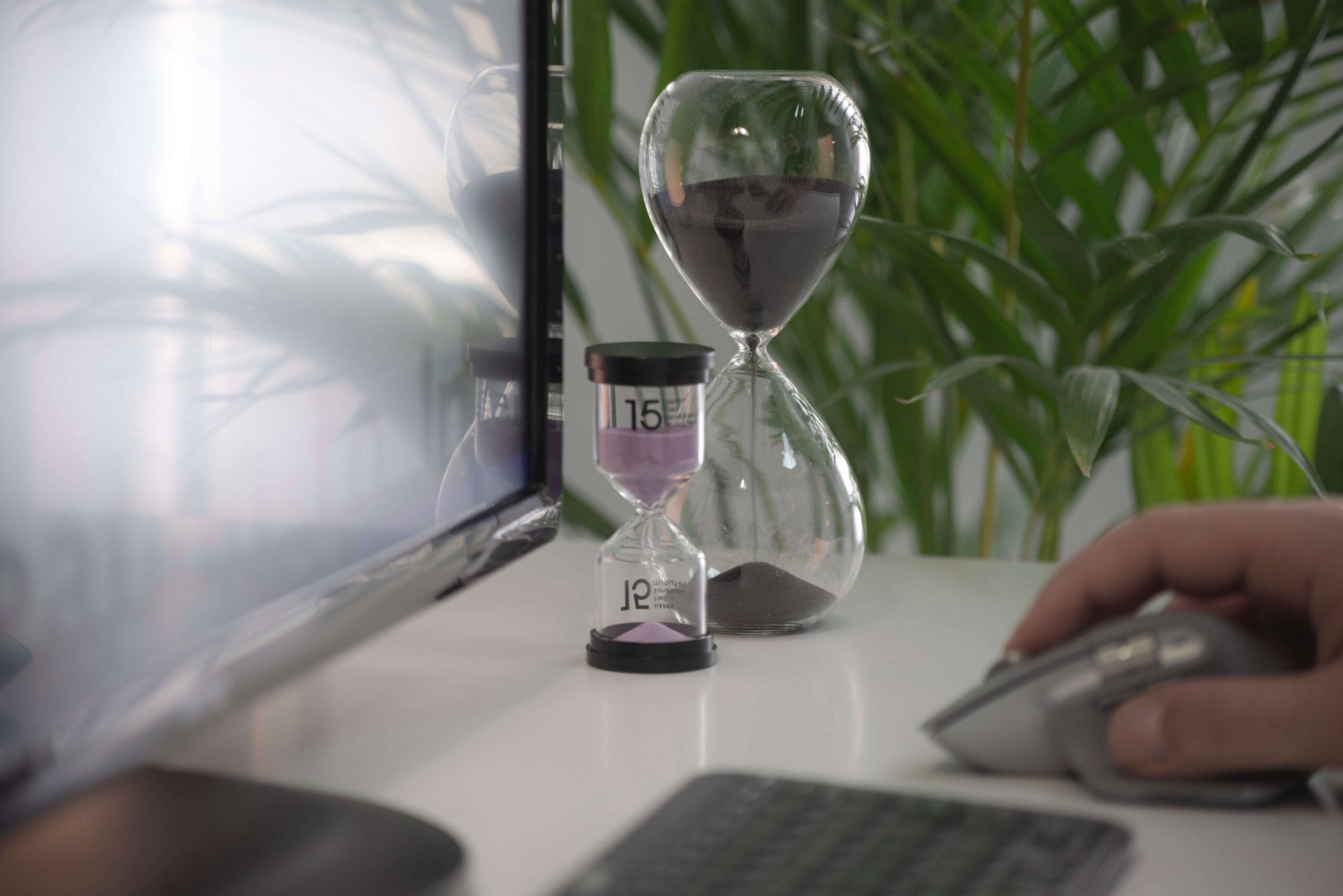 image of two egg timers on a desk beside a screen