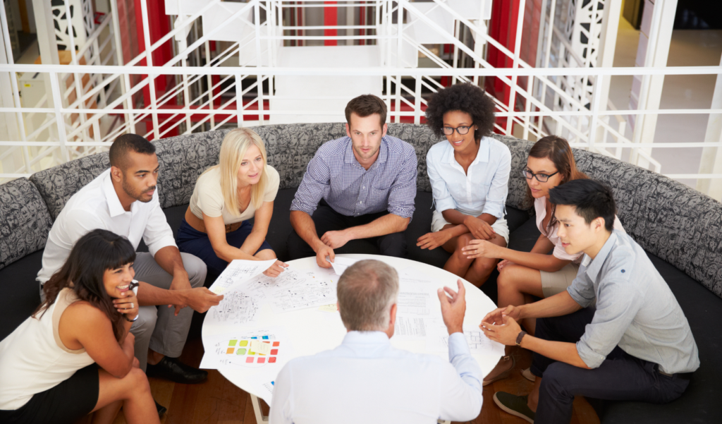 a group of colleagues listening to a man