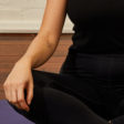 Close up of woman sitting in lotus pose.