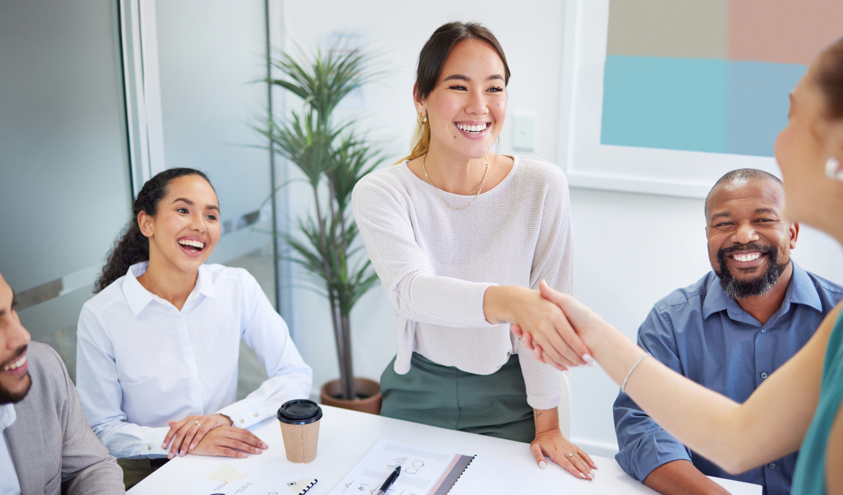 woman shaking her colleague's hand while smiling