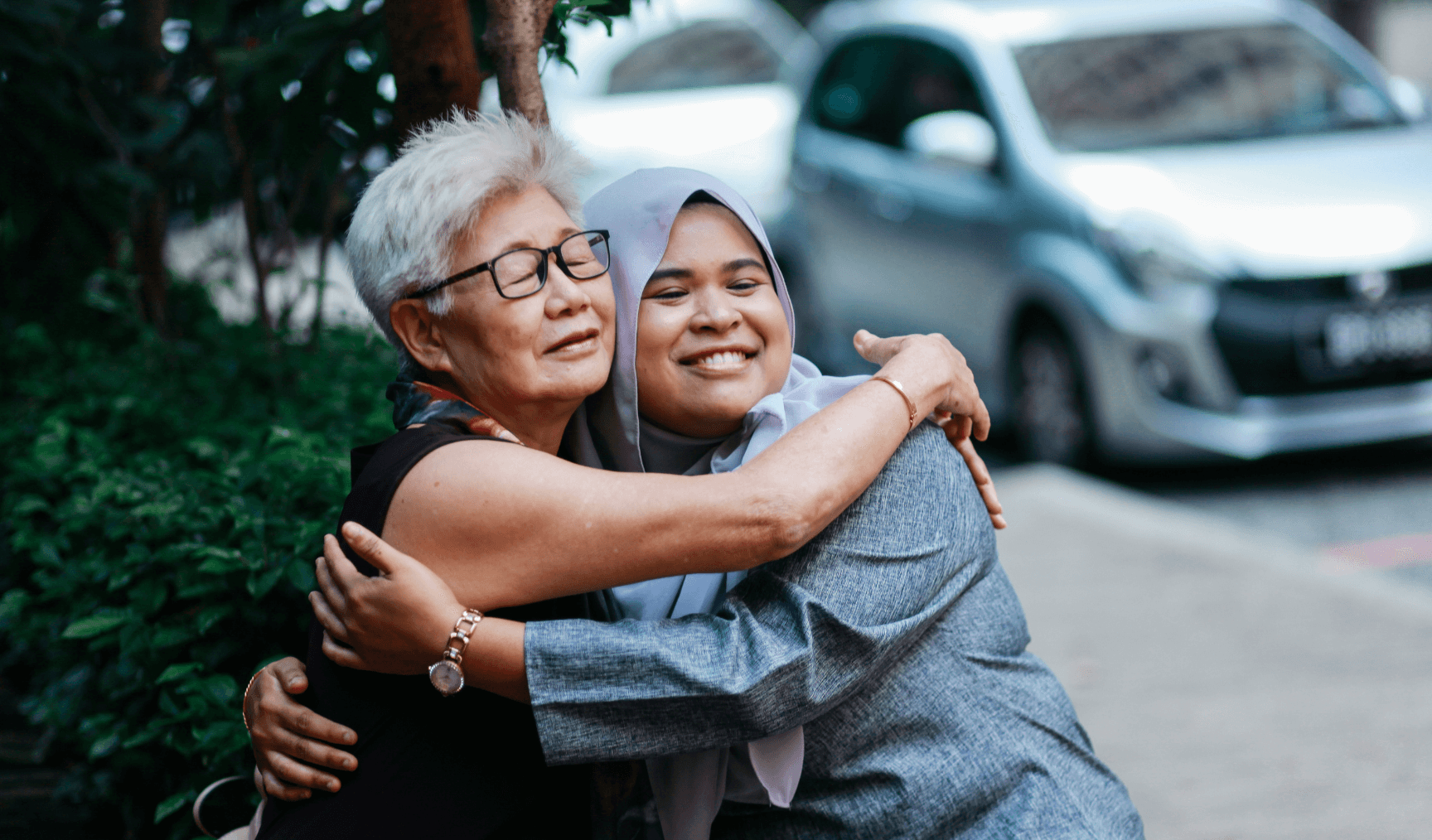 Malay woman hugging a chinese auntie on the street