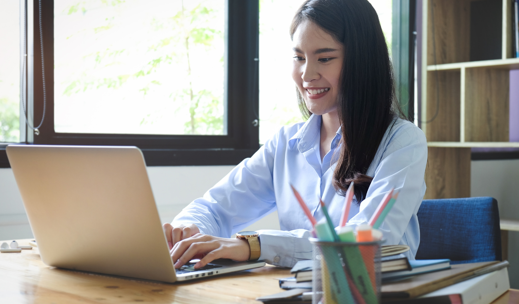 woman typing on her laptop and smiling