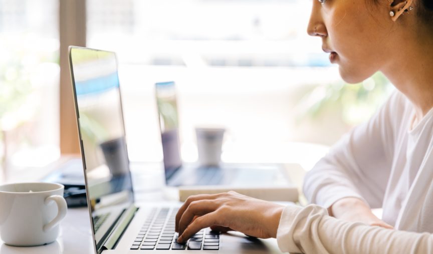 woman typing on her laptop while working