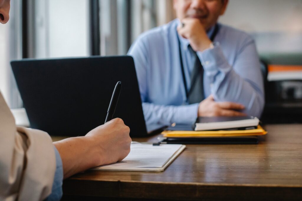 two colleagues talking to each other at a desk