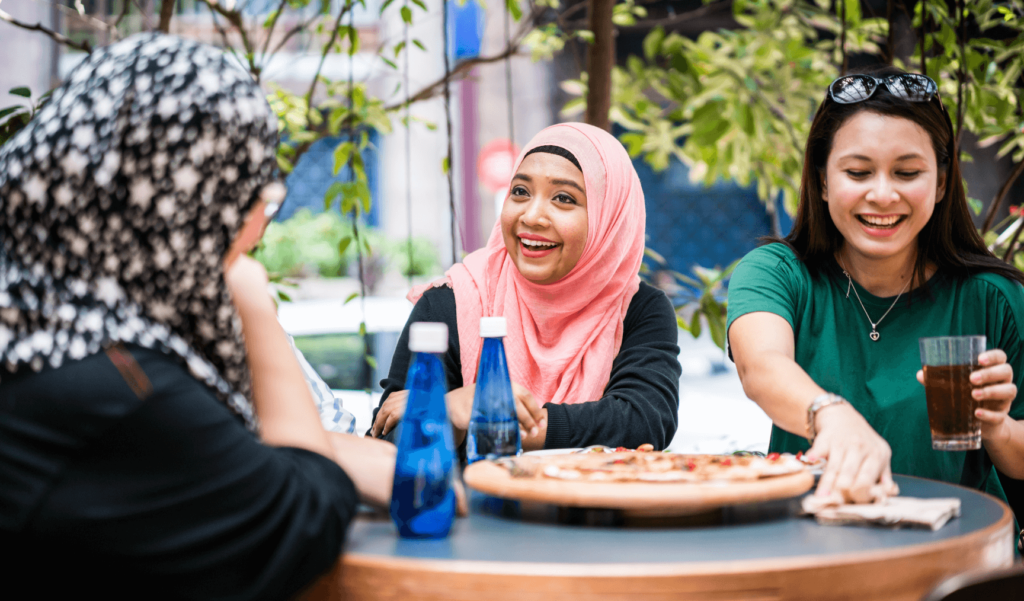 three ladies having fun chatting and eating together