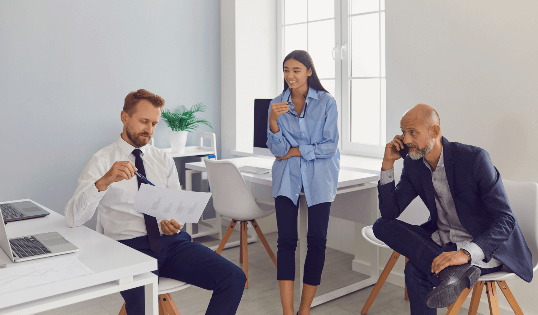 two men and one woman having a discussion at the office