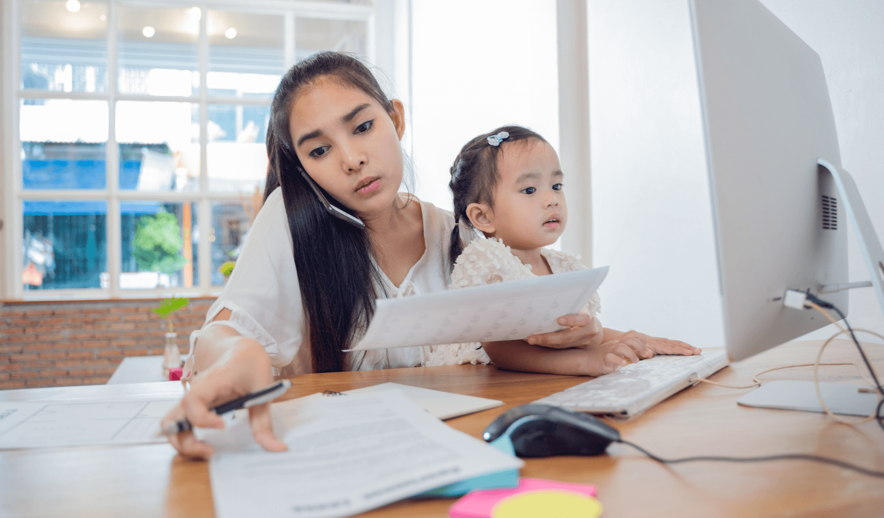 a woman working while holding her child