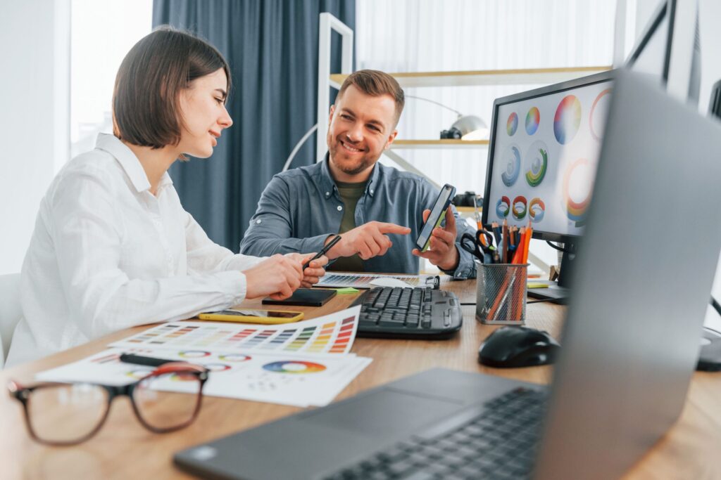 People looking at computer screen at a desk.