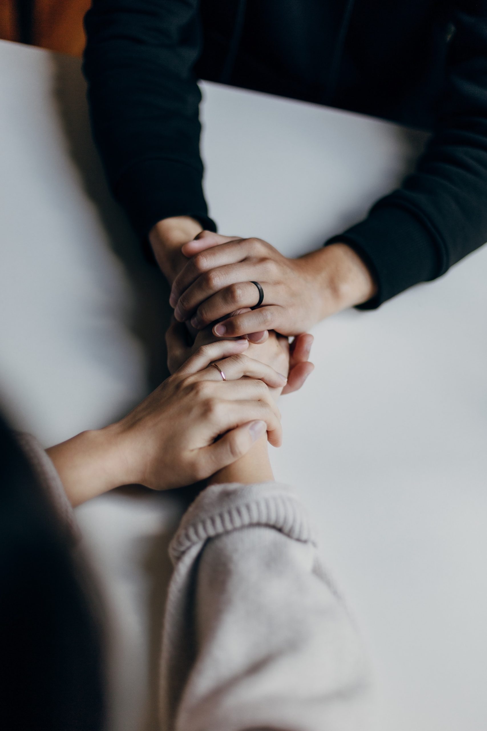 two people holding each others hands across a table