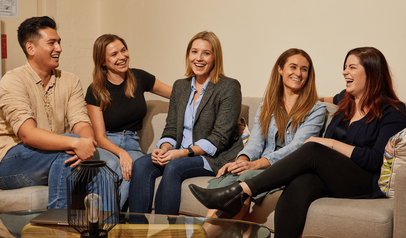 A group of five colleagues laughing together