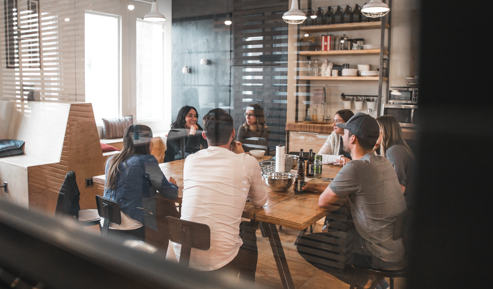 A group of people sit in a meeting room in a creative office