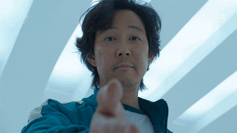 A man in a teal tracksuit reaches out his hand with a serious expression "Wanna do this together?"
