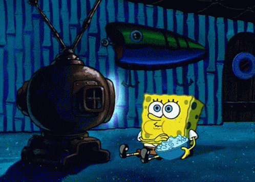 Cartoon character Spongebob eating popcorn in a dark room in front of a television