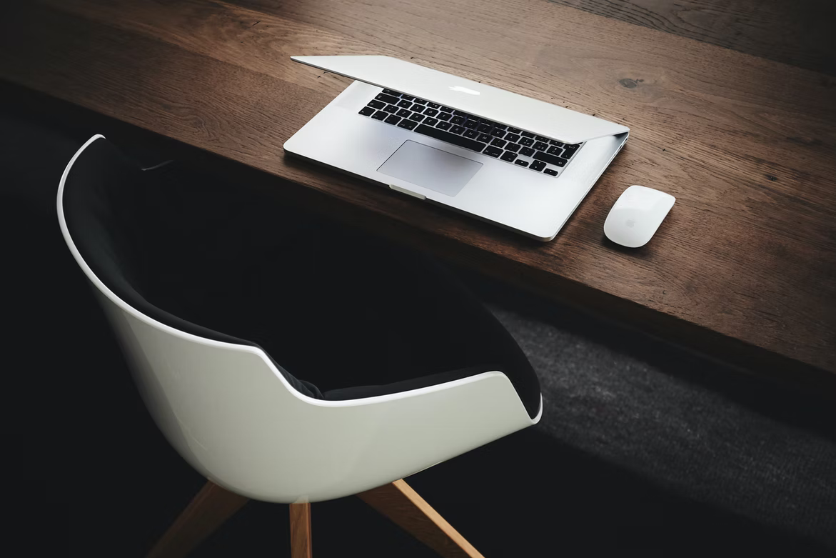 empty chair with laptop on table