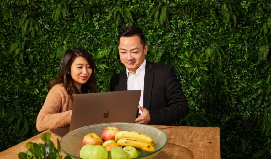 two employees having a discussion in front of a laptop