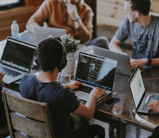 A group of people sitting at a shared table on their laptops