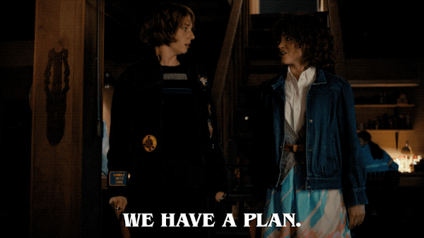 Two teenage girls stand next to each other looking excited and saying "we have a plan"