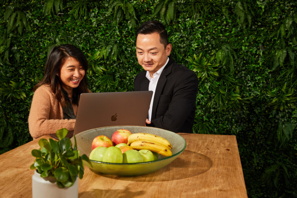 HR and a manager smiling and sitting at the table with a laptop.
