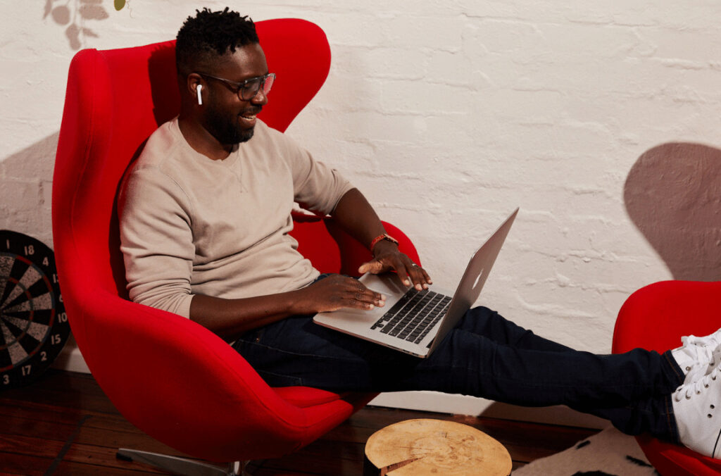 Man sitting on a couch listening to a NZ podcast
