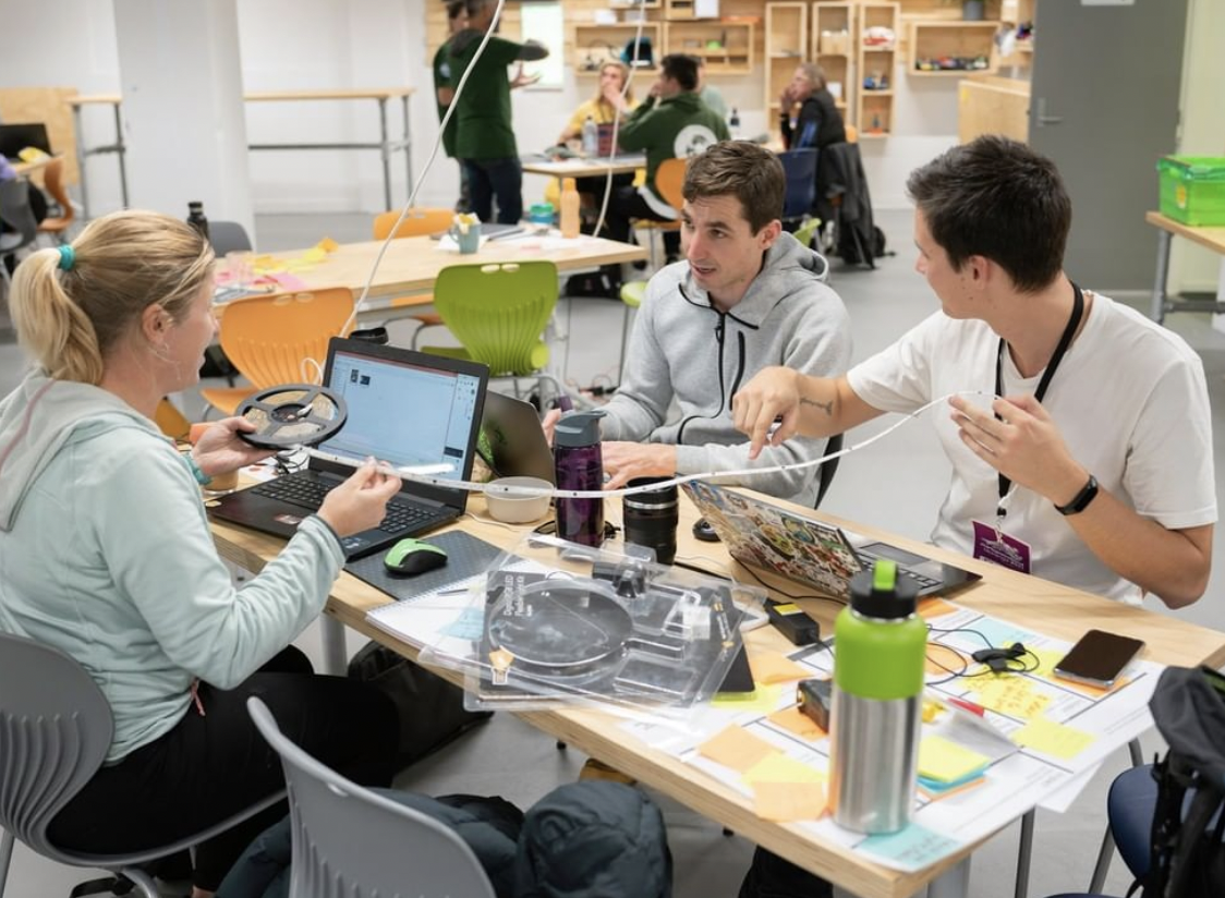 Three people sitting round a table sharing ideas