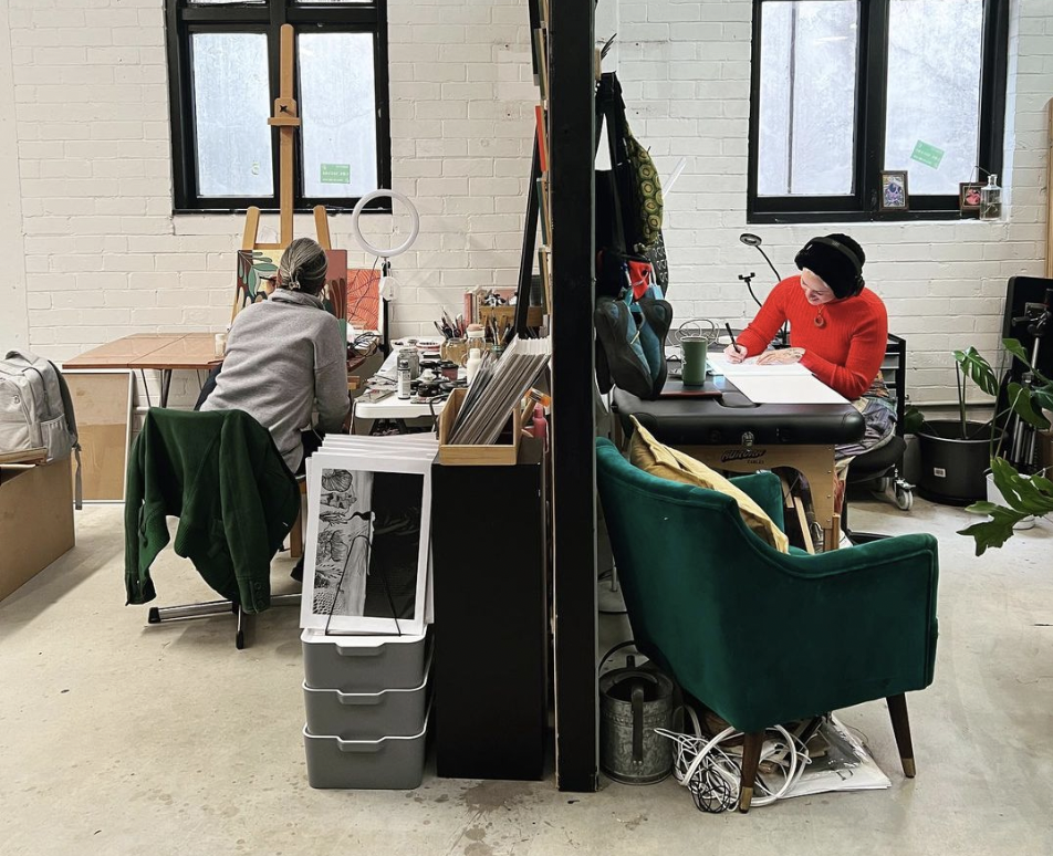 Two artists working at different desks