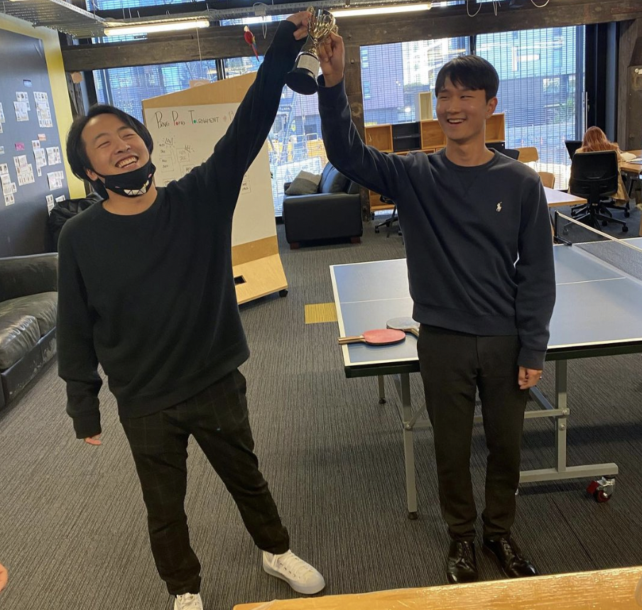 Two colleagues holding a trophy while smiling