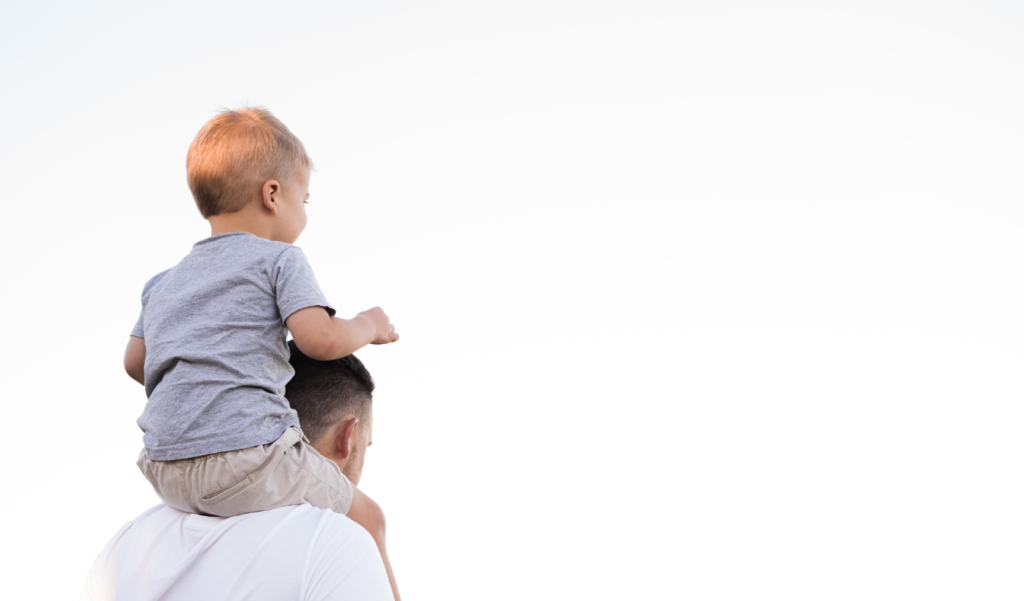 Man walks away with a small boy on his shoulders