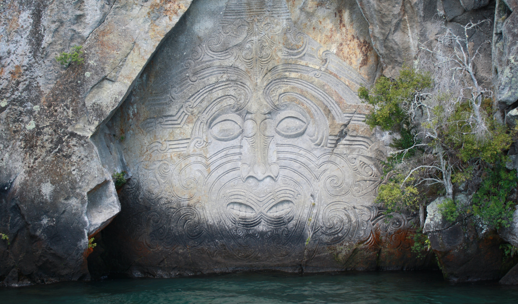Maori carving on the wall of a cliff