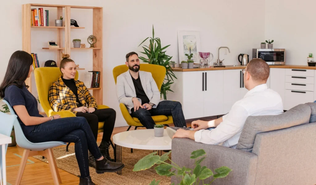 People gathered in a living room, engaged in conversation