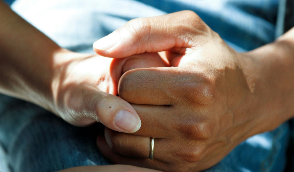 Two people's hands clasped