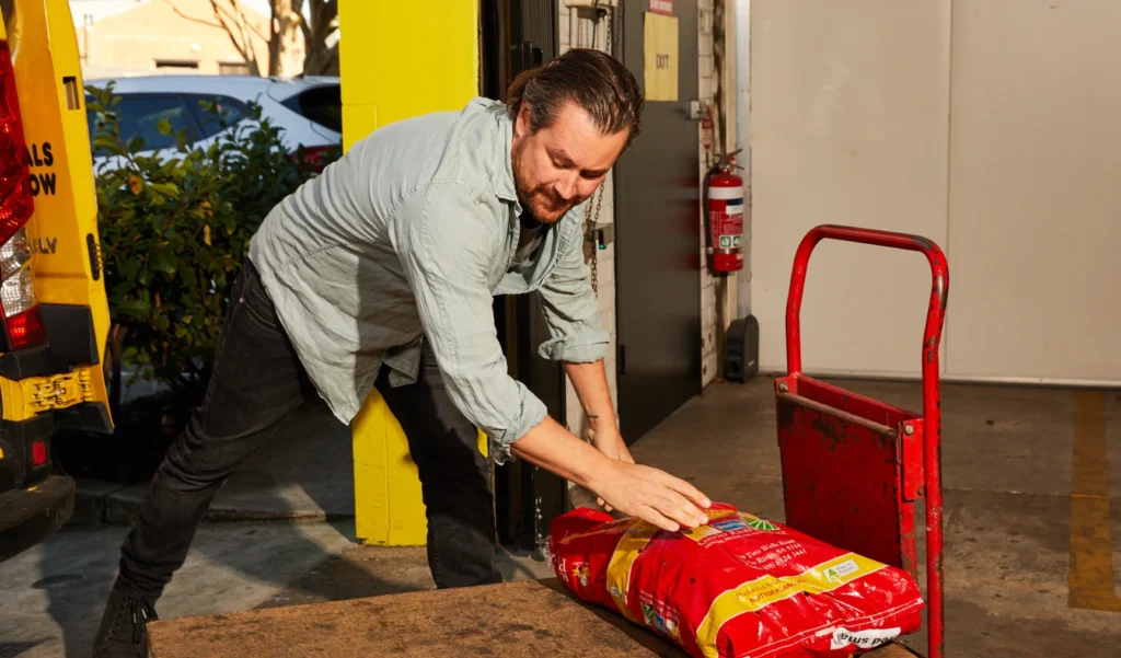 Man loading a sack on a cart