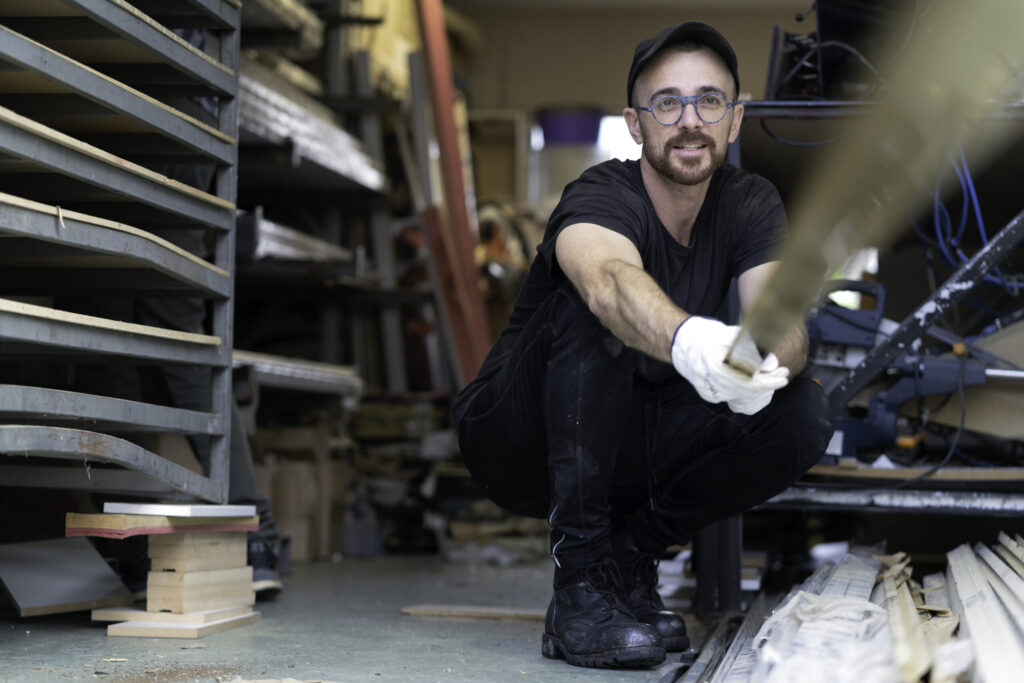 manufacturing worker smiling while carrying out duties.