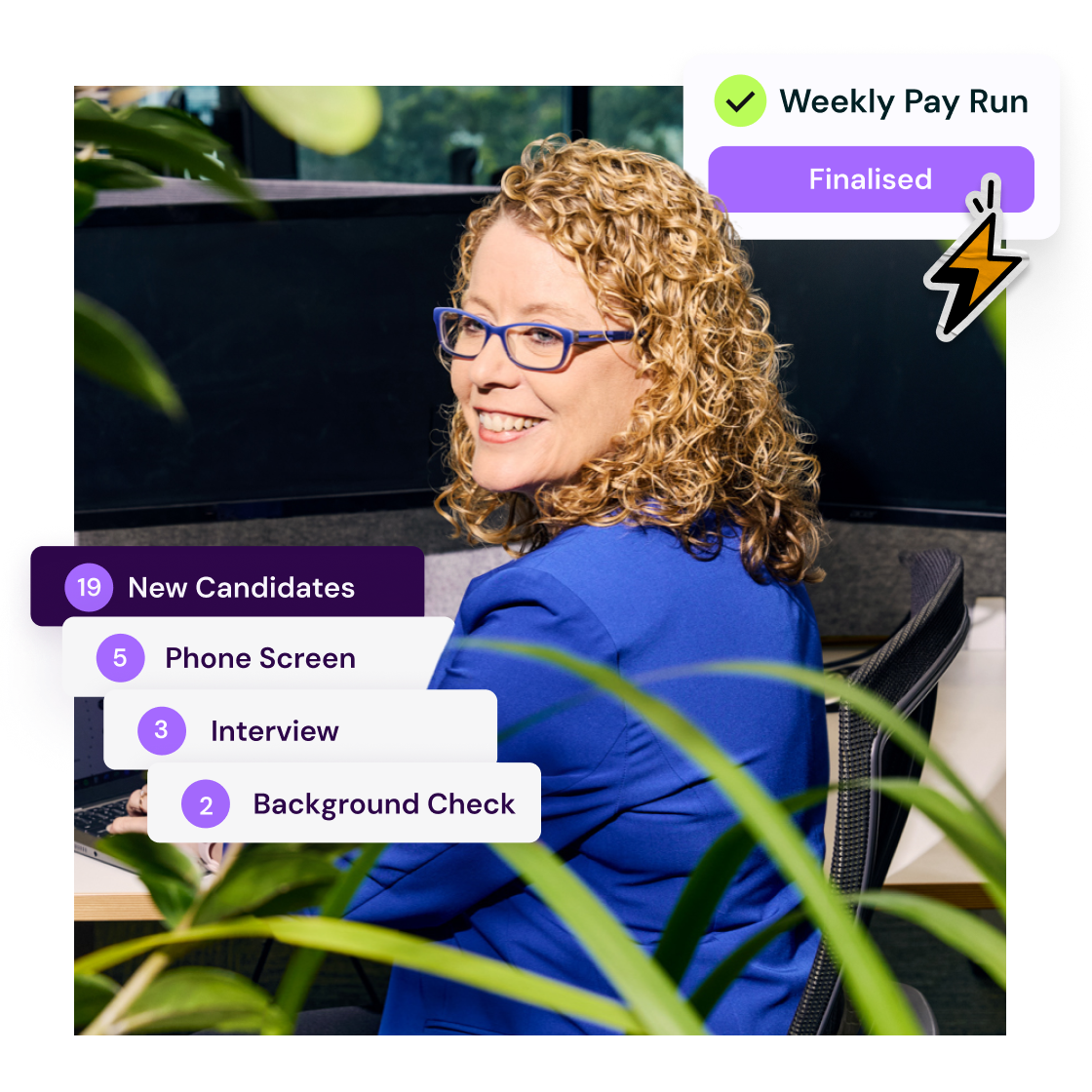 Smiling woman with curly hair at her desk, surrounded by plants
