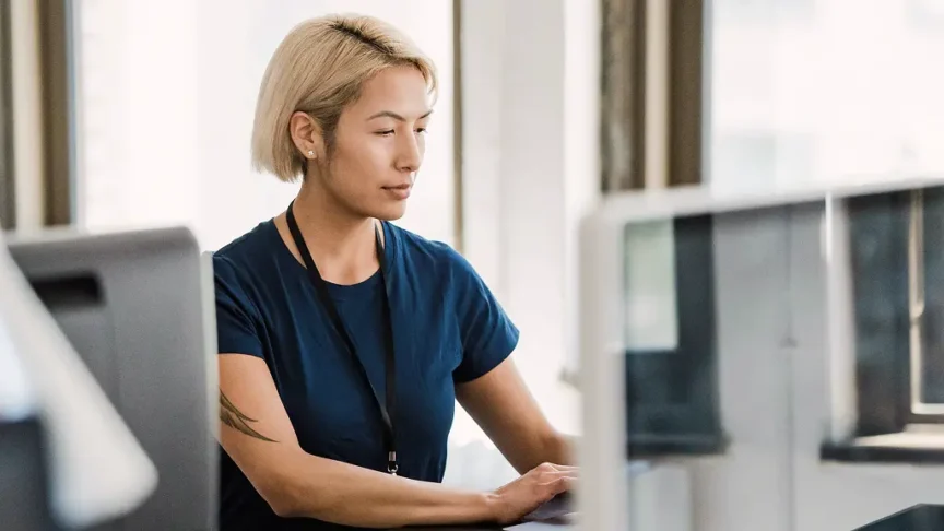 Woman working at a computer in an office setting.