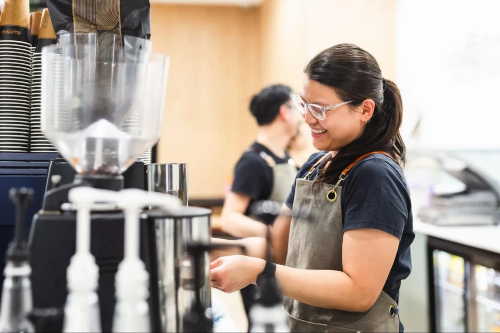 Smiling barista as she prepares coffee