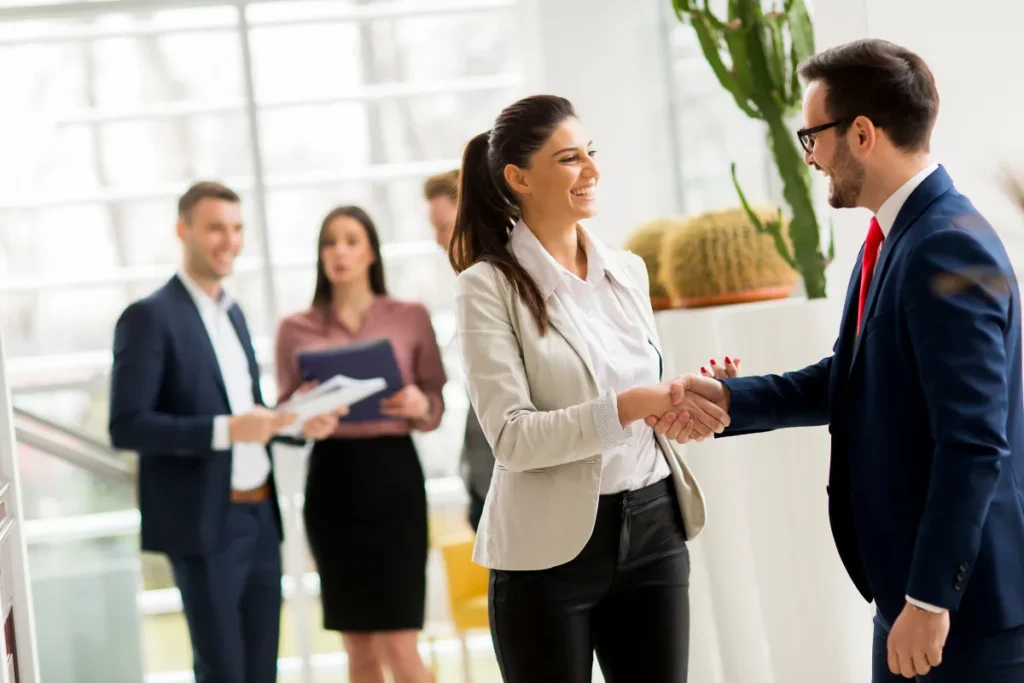 Woman shaking the hand of a man in a meeting