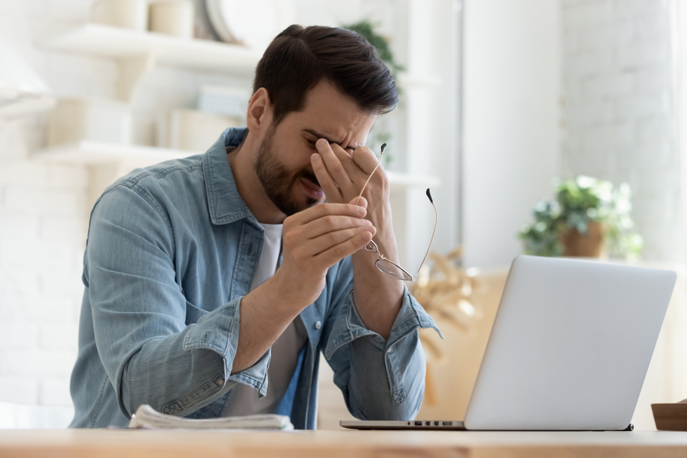 Man sitting at work desk looking distressed